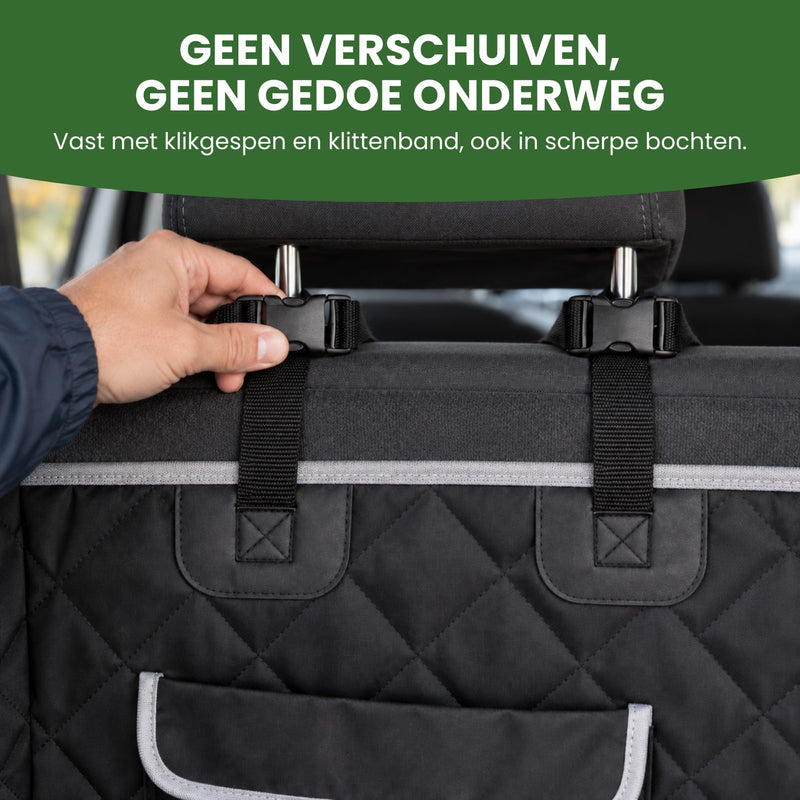 Hand houdt de klikgesp van de PawCover vast om de hoofdsteun van de achterbank: geen verschuiven, geen gedoe onderweg
