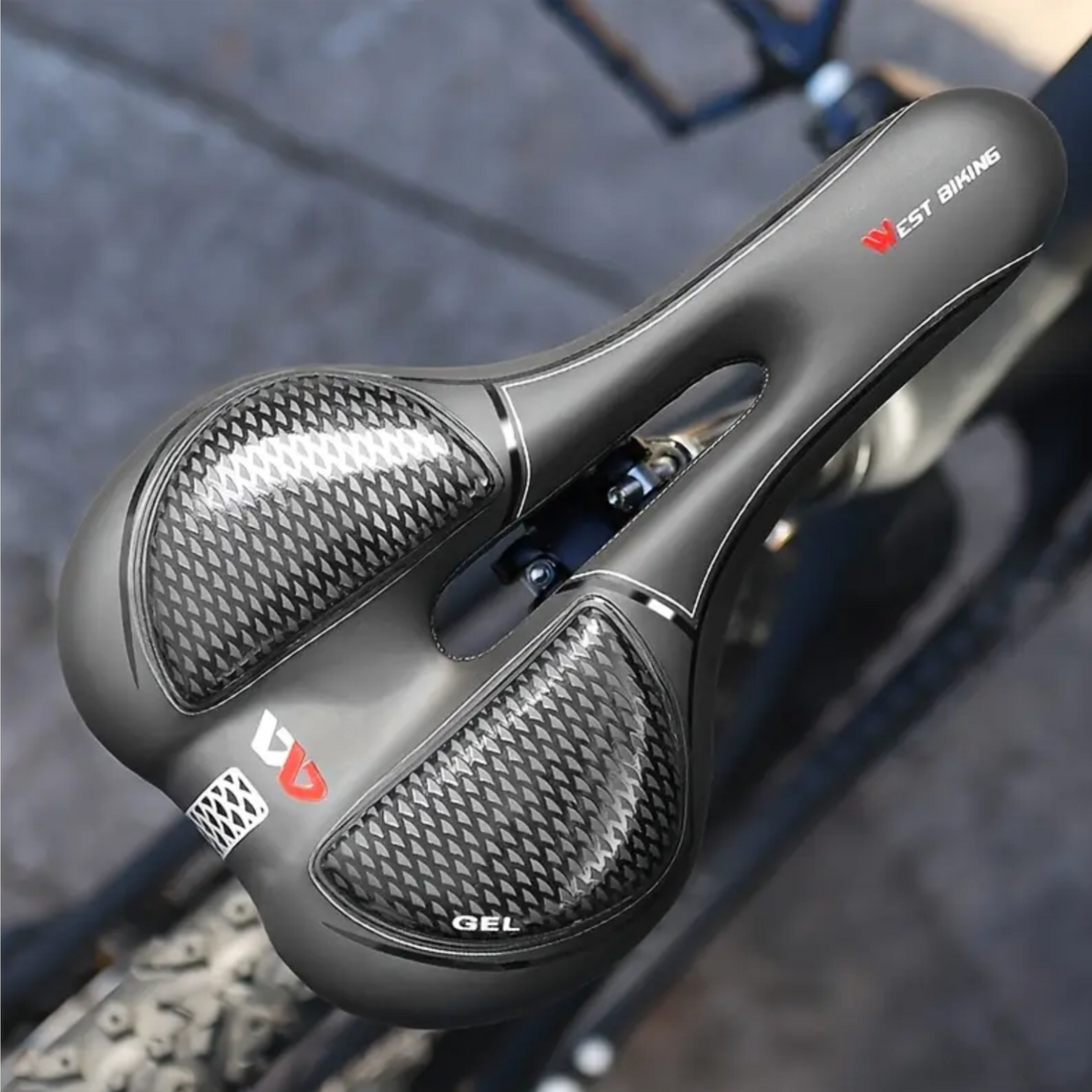 Black ergonomic bicycle saddle with gel and ventilation, mounted on a carbon seatpost.