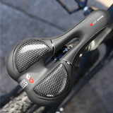 Black ergonomic bicycle saddle with gel and ventilation, mounted on a carbon seatpost.