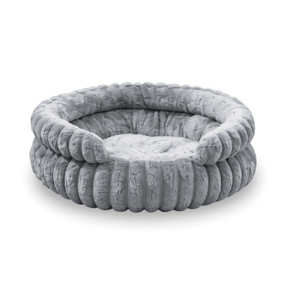 Round grey plush dog bed with raised soft edges and padded sleeping cushion.