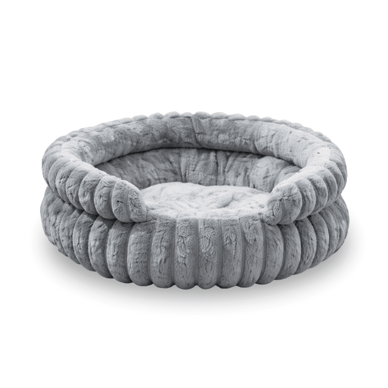 Round grey plush dog bed with raised soft edges and padded sleeping cushion.