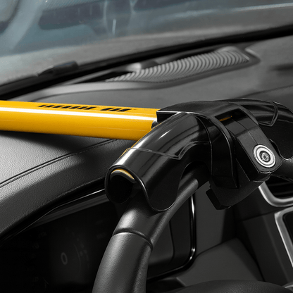 Close-up van geel-zwart stuurslot op stuurwiel van auto ter voorkoming van autodiefstal.